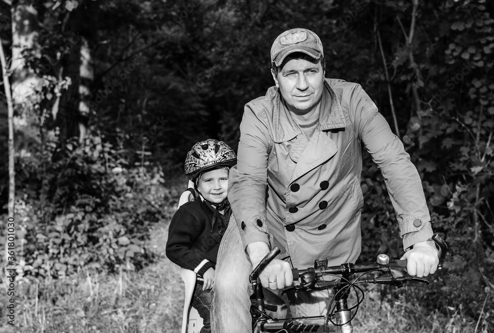 Bicycle ride of father and his son on baby seat. Bicycle ride of father and his son on baby seat.
