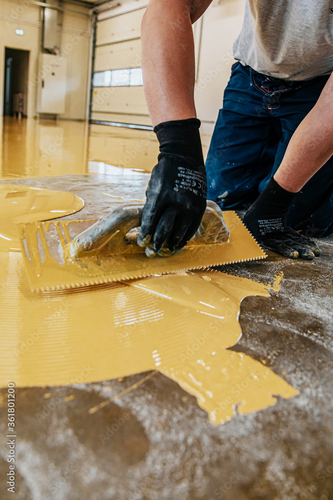 A construction worker apply epoxy resin in an industrial hall Stock Photo |  Adobe Stock