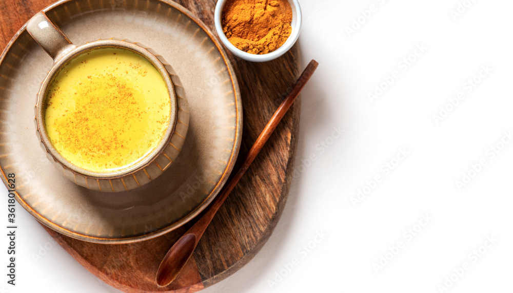Tasty healthy drink made from turmeric, milk and spices in a mug on a white background top view, free space for text. Golden milk. Latte made from milk and turmeric. Detox drink. Tasty healthy drink made from turmeric, milk and spices in a mug on a white background top view, free space for text. Golden milk. Latte made from milk and turmeric. Detox drink.