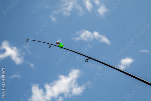 fish bite signaling device on a fishing rod, against the sky