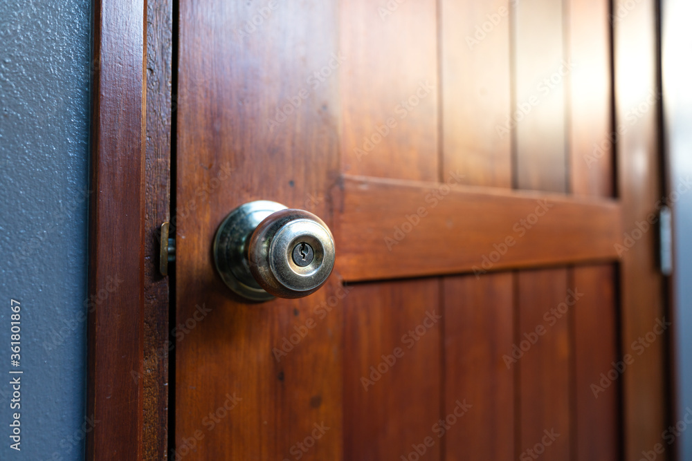 Close-up on brass metallic knob of wooden door, selected focus on the key hole. Interior house equipment object. Close-up on brass metallic knob of wooden door, selected focus on the key hole. Interior house equipment object.