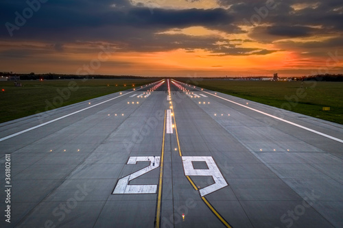 Aerial view on empty airport runaway with markings for landings, designation 29 and all navigation lights on at the colorful sunset, clear for airplane landing or taking off in Wroclaw  airport