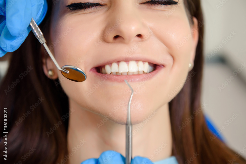 Dentist hands with dental instruments examination patient's teeth in medical clinic