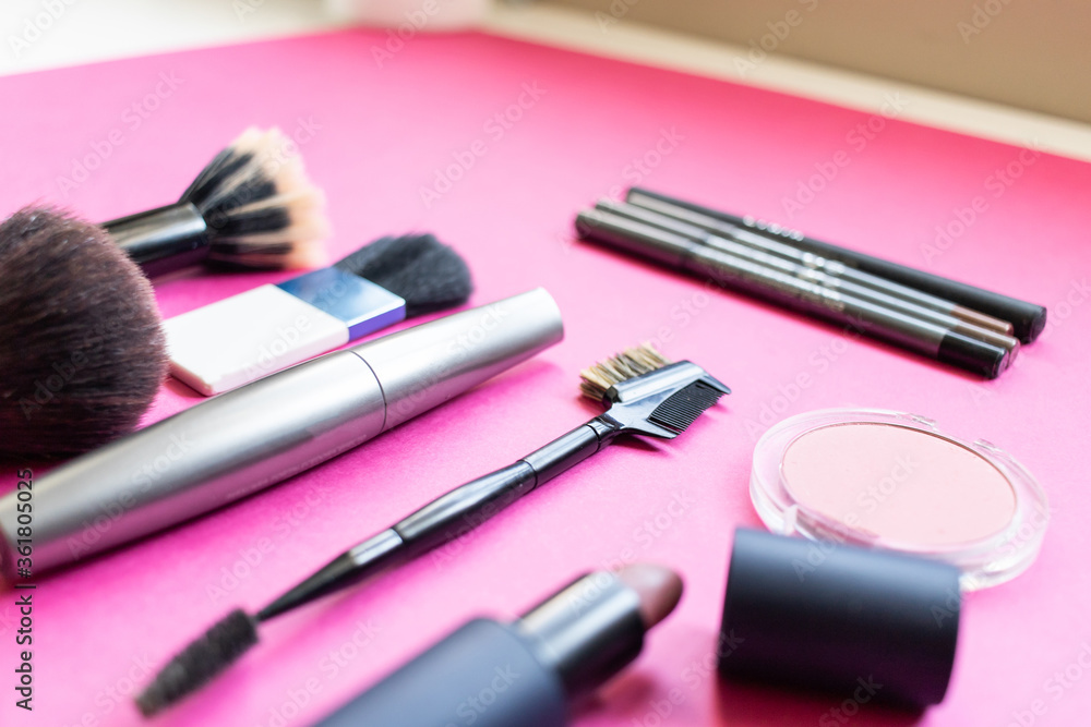 Make up products, brushes, lipstick, eyeliner on a pink background. Beauty concept Make up products, brushes, lipstick, eyeliner on a pink background. Beauty concept