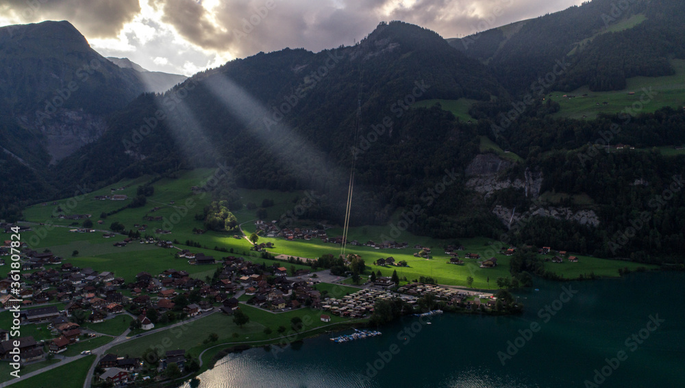  Sunbeams and a beautiful mountain landscape in the Swiss Alps near a lake