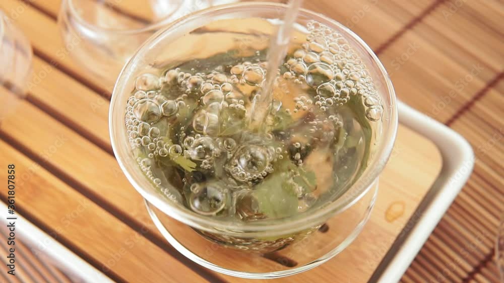 Hot green tea is poured from the teapot. Close-up, tea ceremony Hot green tea is poured from the teapot. Close-up, tea ceremony