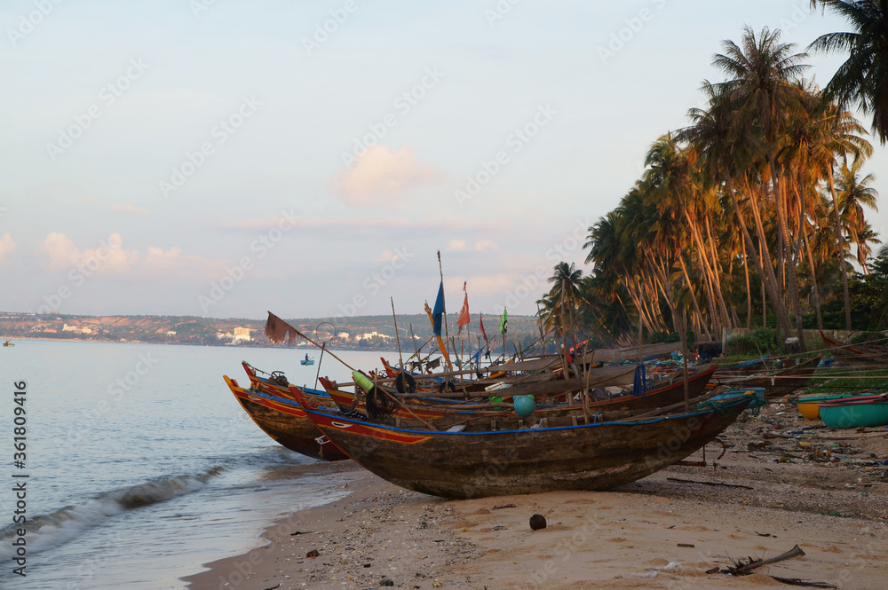 Fishernmans boats and palm trees on sandy beach in the morning Fishernmans boats and palm trees on sandy beach in the morning