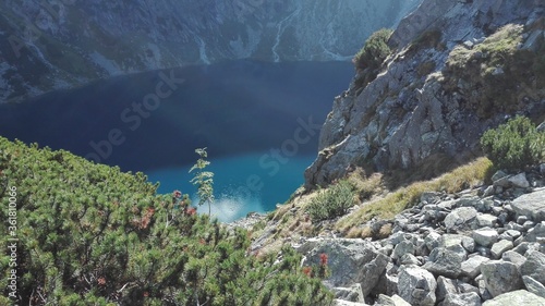 Crystal clear lake with mountain reflection inside a mountain glen.
