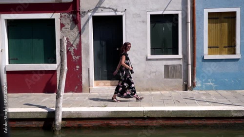Wallpaper Mural Young attractive woman walking near a canal surrounded by colorful buildings. Venice Burano Italy Torontodigital.ca