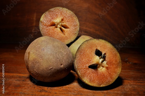 Sawo or Sapodilla isolated on wooden table. Tropical fruit concept