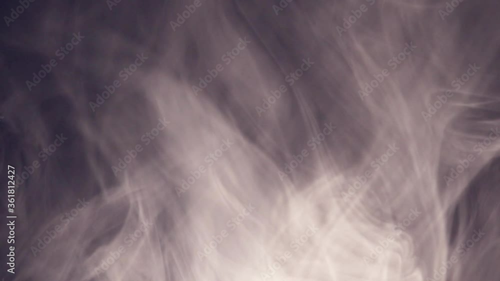 Fancy moving clouds of smoke on a dark background. Smoke movement due to the movement of cold and warm air. Fancy moving clouds of smoke on a dark background. Smoke movement due to the movement of cold and warm air.