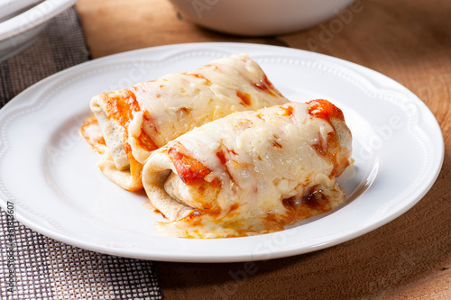 .Pancakes with meat, in tomato sauce and cheese.