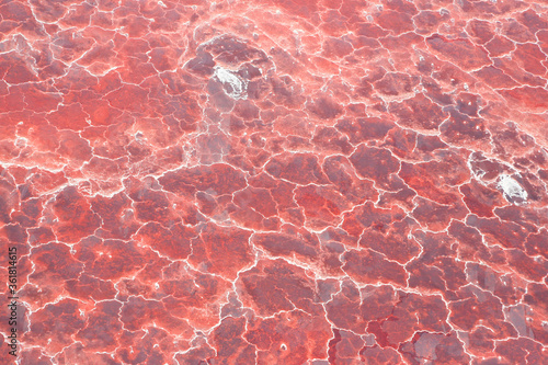 Aerial view of the salt pan and mineral crust with red algae of Lake Natron, in the Great Rift Valley, on the border between Kenya and Tanzania. The Rift Valley contains a chain of active volcanoes.