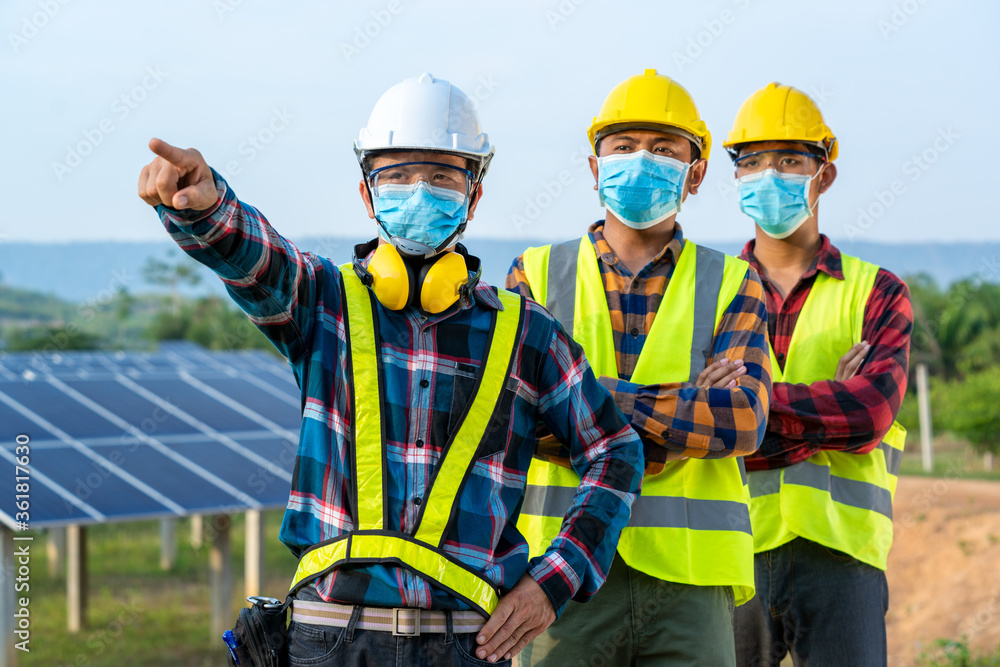 Solar power plant,Electrician wearing a medicine healthcare mask working and checking solar plant at solar power station,Climate change and renewable energy. Solar power plant,Electrician wearing a medicine healthcare mask working and checking solar plant at solar power station,Climate change and renewable energy.