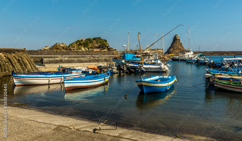 Fishermen's boats against a background of Isole dei Ciclopi at Aci Trezza, Sicily in summer