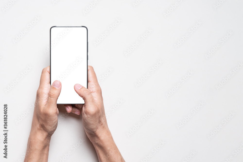 Man uses mobile smart phone with isolated blank white screen. Mockup with copy space. Man uses mobile smart phone with isolated blank white screen. Mockup with copy space.