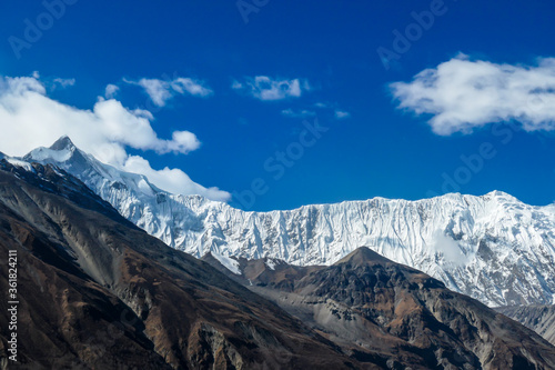 A close up view on high, snow capped Himalayan peaks along Annapurna Circuit Trek in Nepal. Barren and sharp slopes. Exploration and discovering new places.