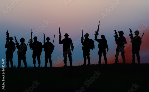 Team special forces. soldier assault rifle with silencer.Silhouette action soldiers hold weapons.military and danger concept.