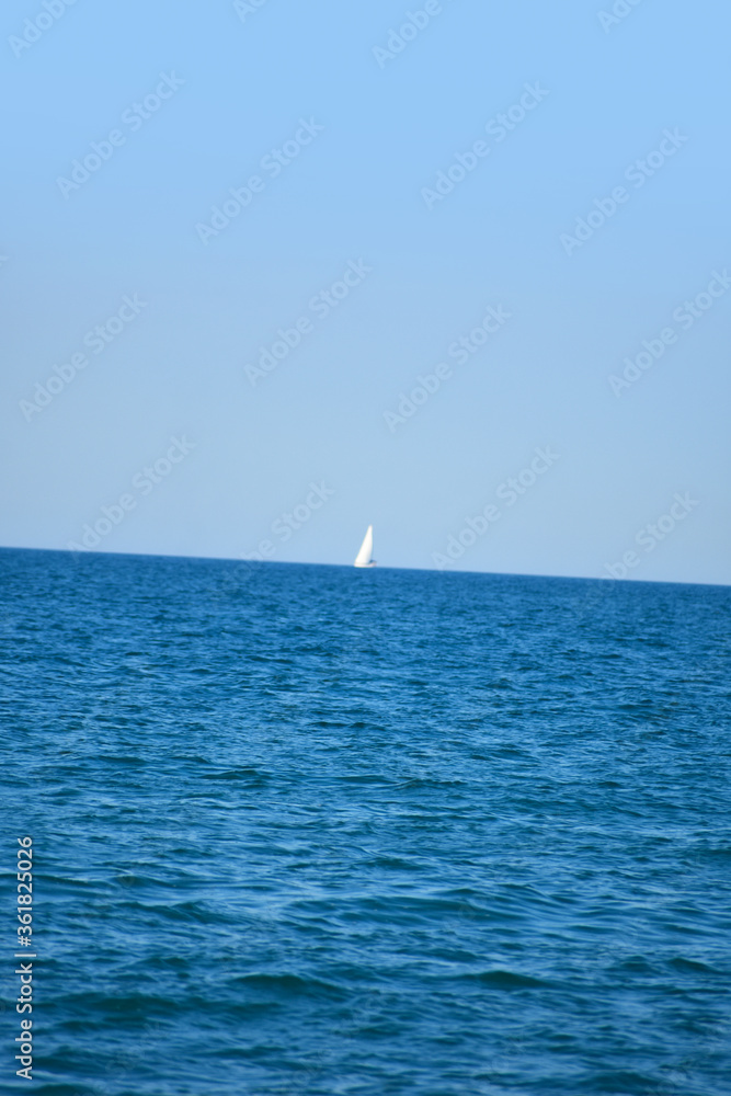 Sailboat on ocean or lake with deep blue waves
