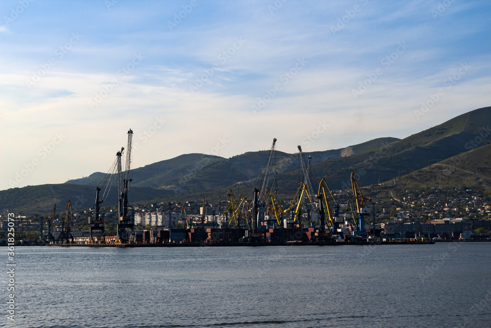Sea port on a sunny day. Harbor cranes and containers.