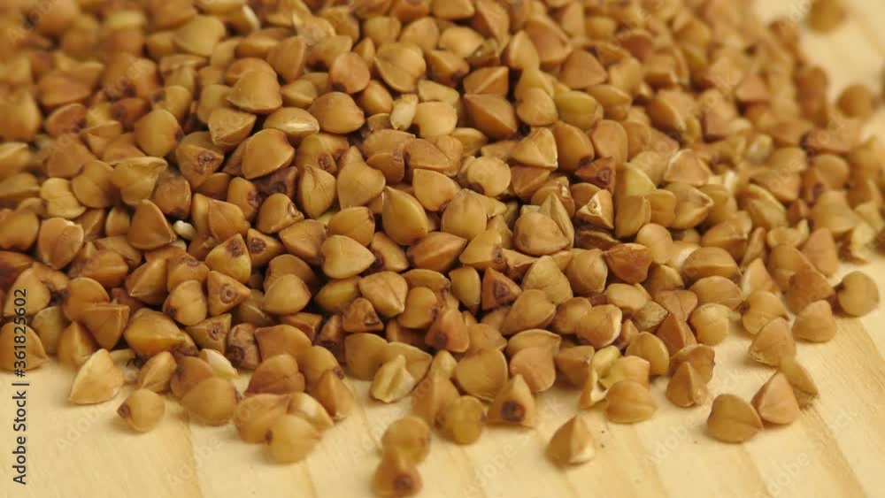 Heap Raw Buckwheat Seeds on a wooden table Heap Raw Buckwheat Seeds on a wooden table
