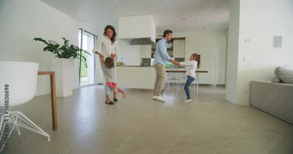Authentic shot of carefree happy smiling parents and kids are having fun to dance together just moved into a new house. Authentic shot of carefree happy smiling parents and kids are having fun to dance together just moved into a new house.