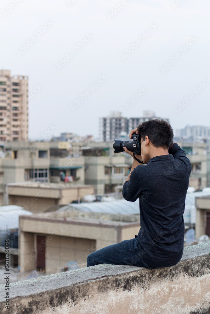 Young photographer clicking photographs at terrace during world pandemic. Solo Explorer. Young photographer clicking photographs at terrace during world pandemic. Solo Explorer.