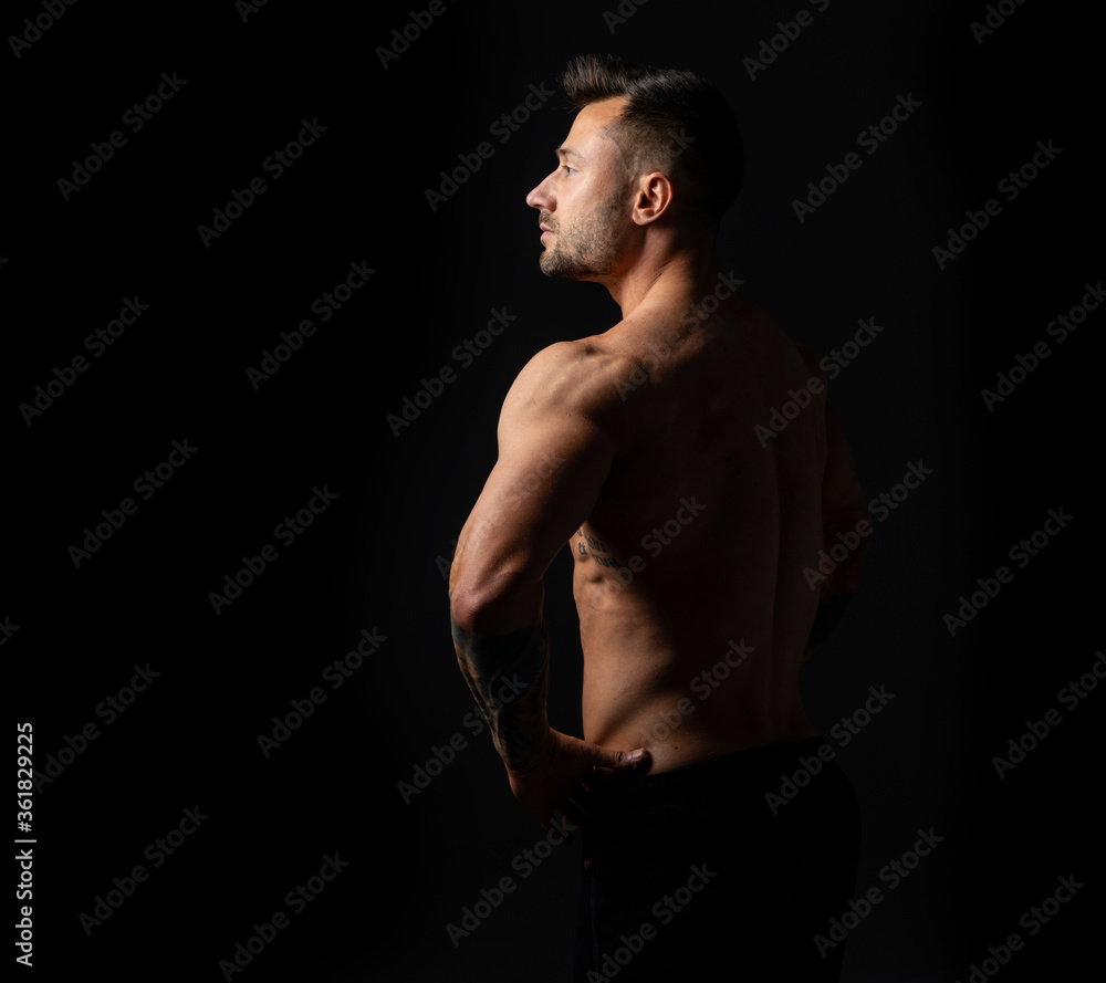 Profile portrait strong man. Male bodybuilder with a naked torso on a black background. Studio photo. Profile portrait strong man. Male bodybuilder with a naked torso on a black background. Studio photo.