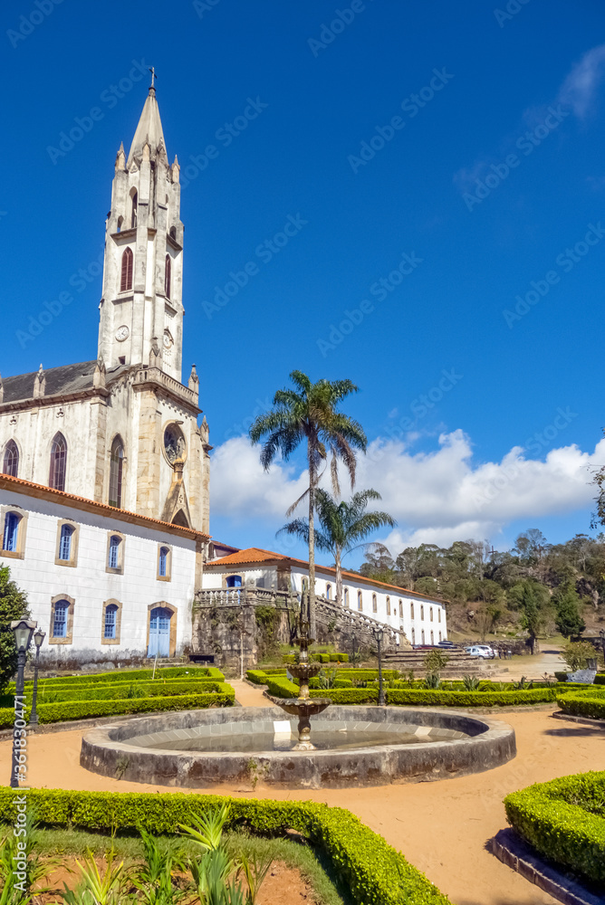 Old neo-Gothic church and side buildings of the sanctuary complex, seen from the garden, with blue sky in the background, Caraca Sanctuary, city of Catas alta, state of Minas Gerais, Brazil