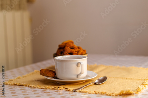 Taza de té negro con azúcar, limones y galletas en el fondo de la mesa rústica