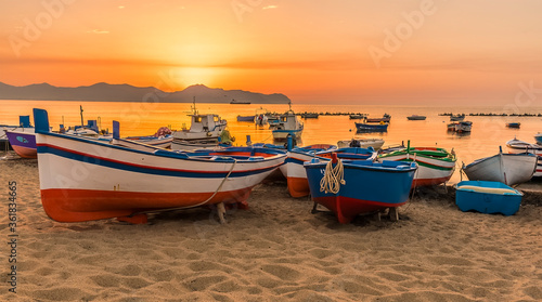 Colourful fishing boats pulled onto the beach Aspra Sicily at sunset on a summer's evening photo