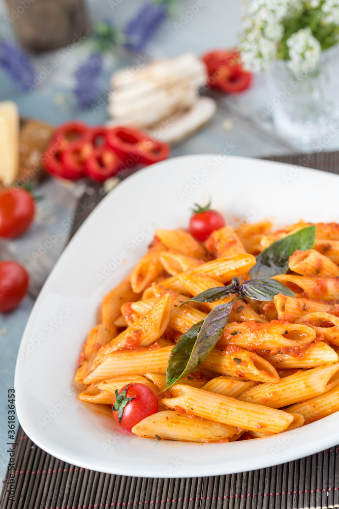 Penne pasta in tomato sauce with chicken, tomatoes decorated with parsley Penne pasta in tomato sauce with chicken, tomatoes decorated with parsley