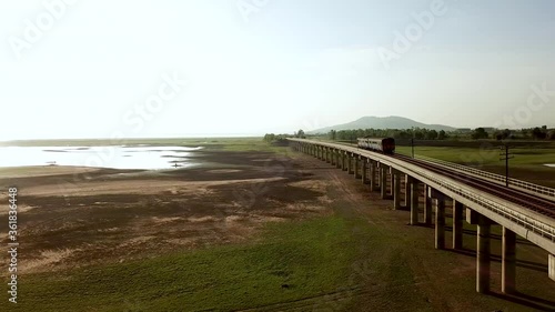 Wallpaper Mural aerial view diesel train runs on a railway bridge above grassland across the lake of Pa Sak Jolasid dam in Lopburi,Thailand during morning sunrise. Torontodigital.ca