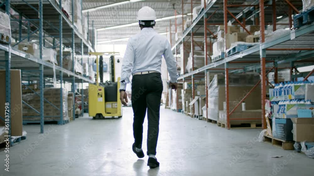 A warehouse manager checks inventory and logistics for an eCommerce facility. Back to work and business is booming. Shot in 4k. A warehouse manager checks inventory and logistics for an eCommerce facility. Back to work and business is booming. Shot in 4k.