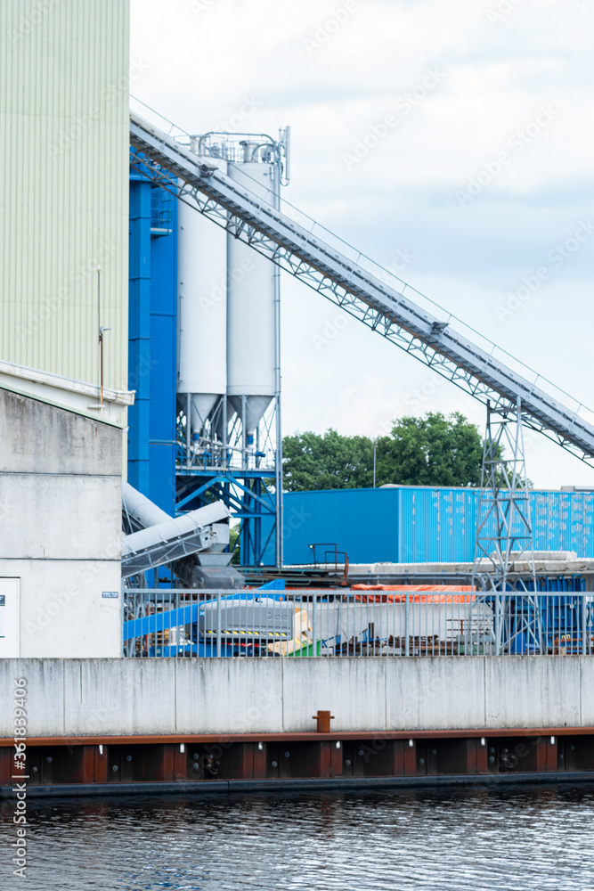 Industrial view of a blue factory buildings, concrete plant with silos and a chute.