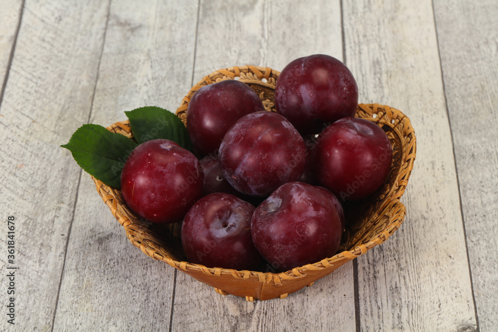 Plum heap in the wooden basket Plum heap in the wooden basket