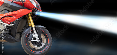 image of a driving motorcycle with headlights on