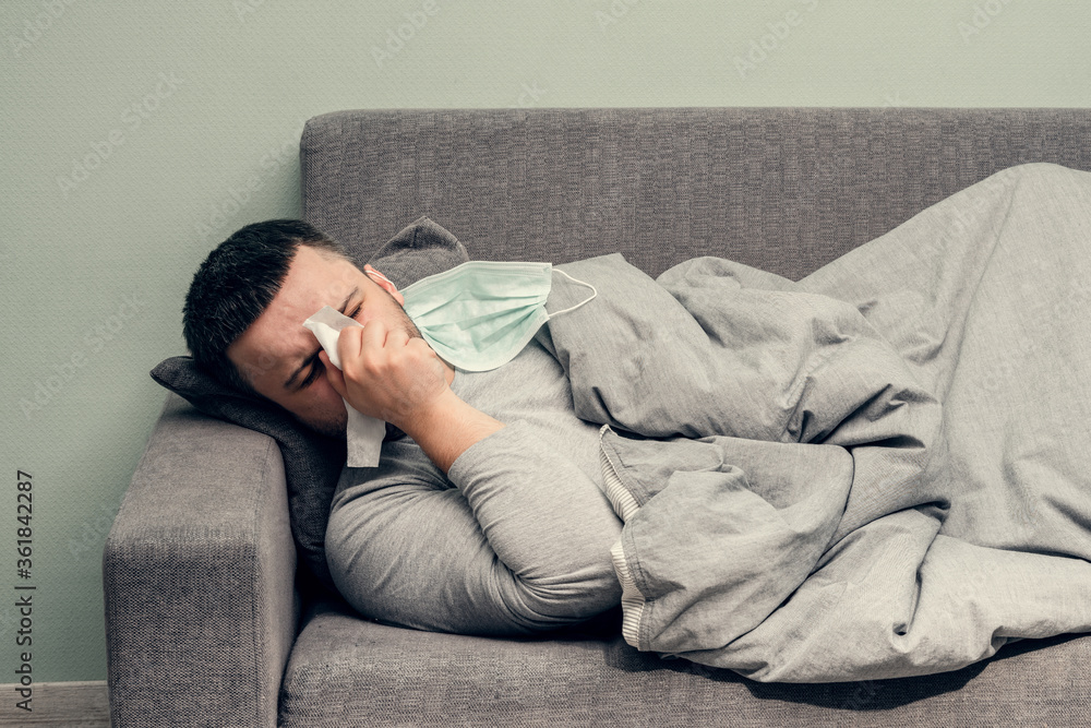 Disease. Cheer at home. A young man is sick, is treated at home. Blows her nose into a napkin, runny nose. Infection, epidemic, bacillus carrier. Disease. Cheer at home. A young man is sick, is treated at home. Blows her nose into a napkin, runny nose. Infection, epidemic, bacillus carrier.