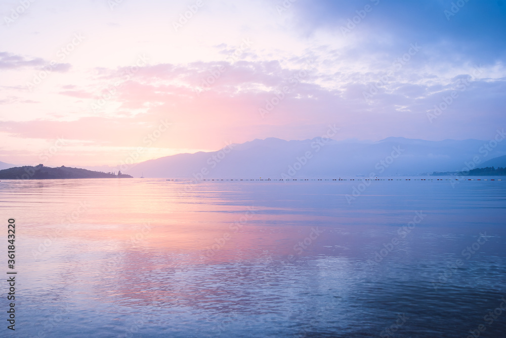 Pink and blu sunset in the sea on a background of mountains