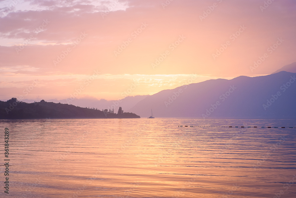 Pink sunset in the sea on a background of mountains