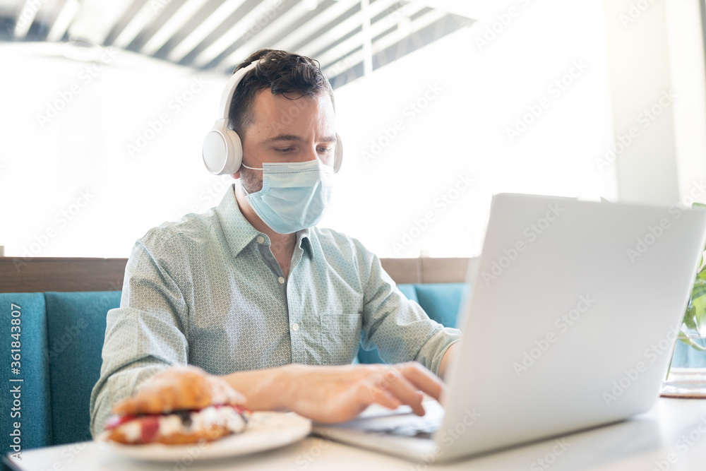 Man Using Laptop In Restaurant Man Using Laptop In Restaurant