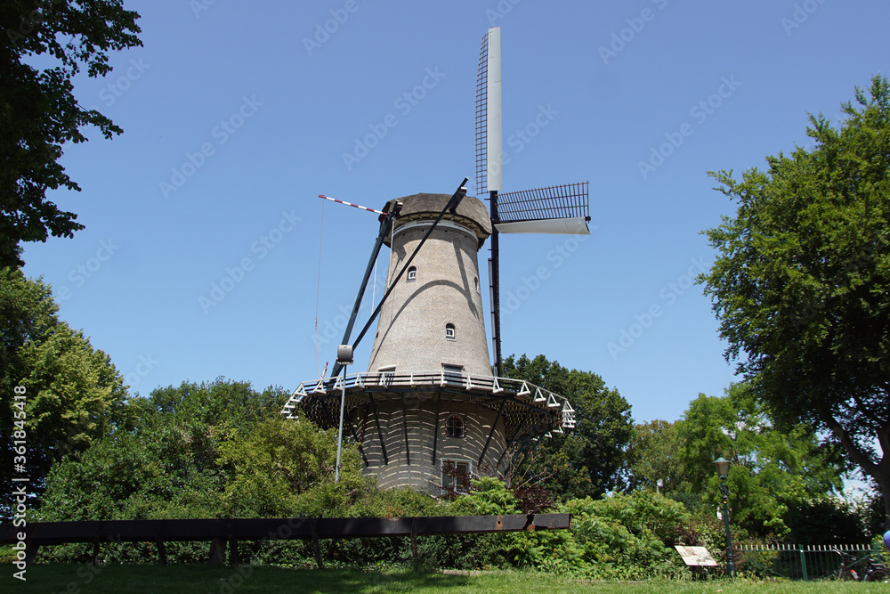 The high brick windmill 'Molen van Piet' for grinding corn on a defensive wall and garden in the Dutch city Alkmaar. Netherlands, June 22, 2020.