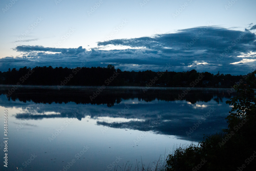 Dark night clouds reflecting off lake