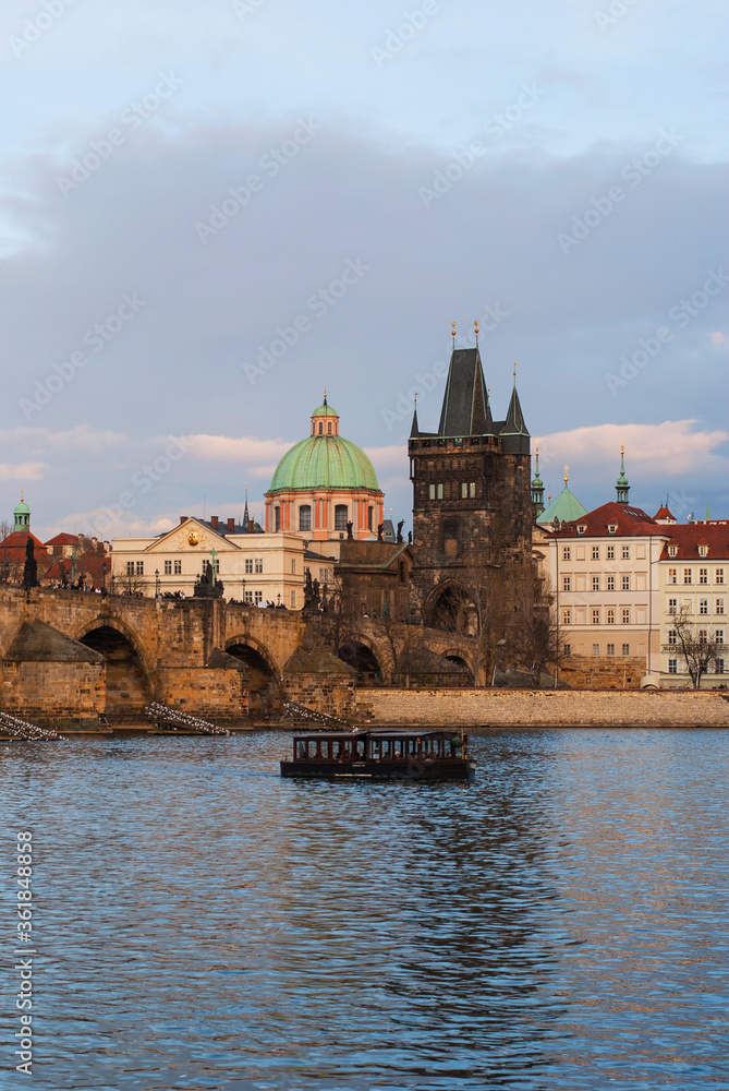 Panorama of the city of Prague, Czech Republic on a sunny day. View of Charles Bridge and the bank of the Vltava River. The ship is sailing along the river.