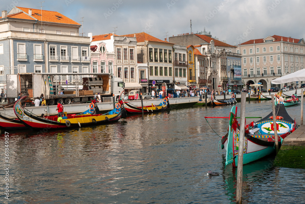 river lined with colourful boat and European building with orange roofs in Portugal