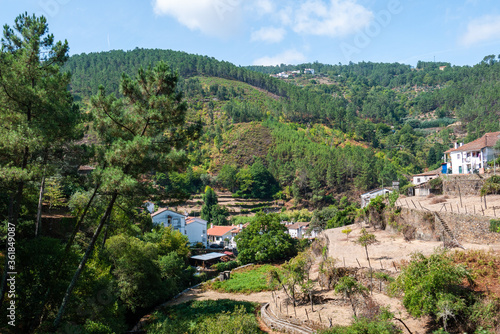 Little village surrounded by hills and green trees