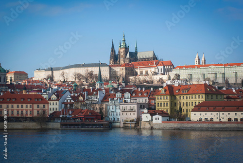 Panorama of Prague, Czech Republic. View of St. Vitus Cathedral from afar, buildings on the embankment of the Vltava River in the foreground.