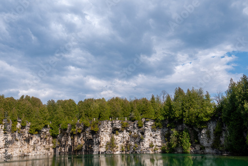 cloudy sky before rain overlooking a tree lined cliff photo