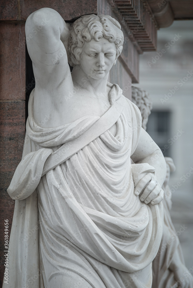 Fototapeta premium Statue of beautiful Roman noble man at the obelisk in the Old Market square (Alter Markt) in downtown of Potsdam, Germany