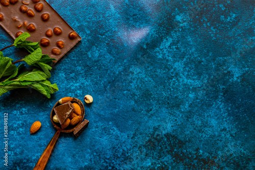 Chocolate chunks with hazelnuts isolated on blue background